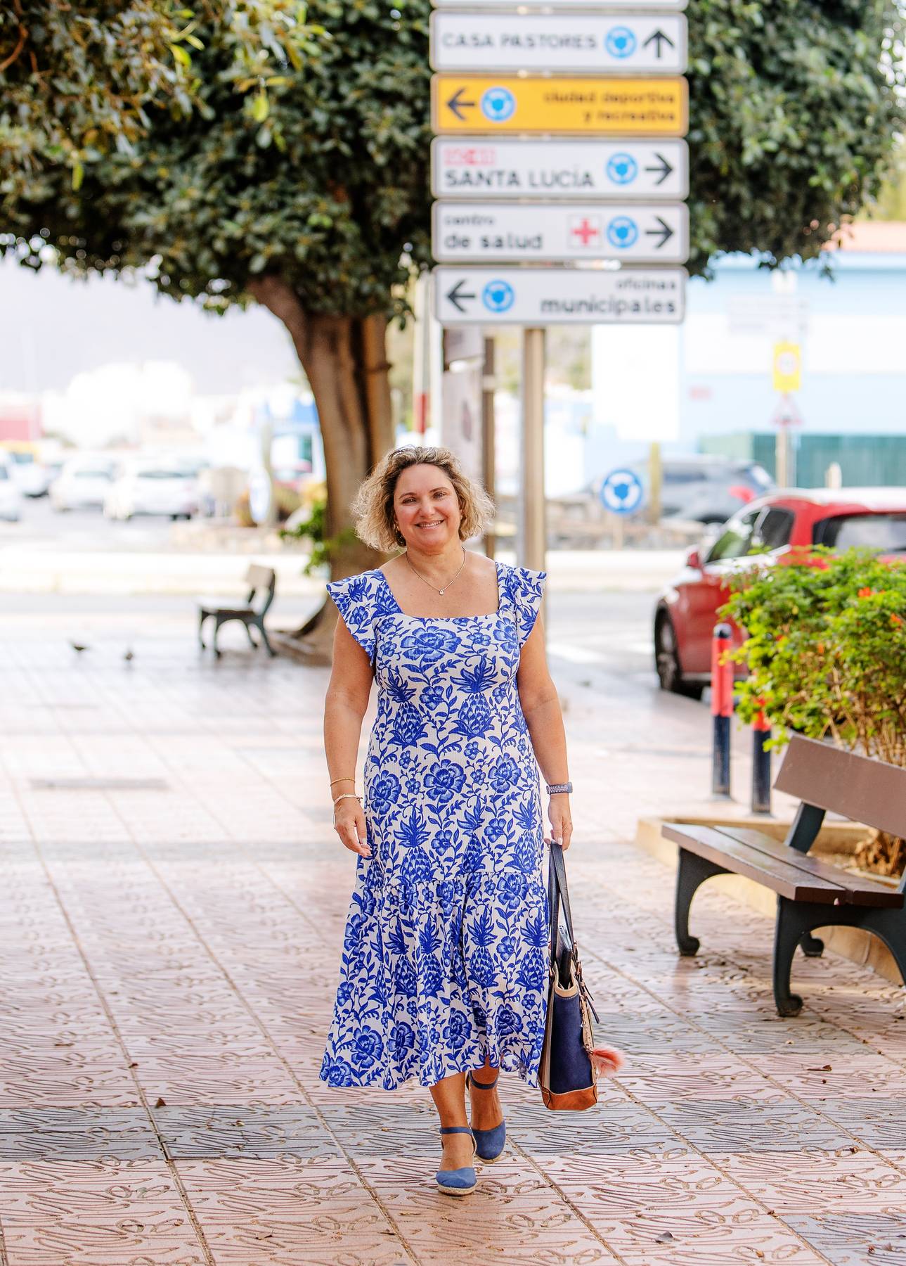Sian Walking along a street with a signpost behind.